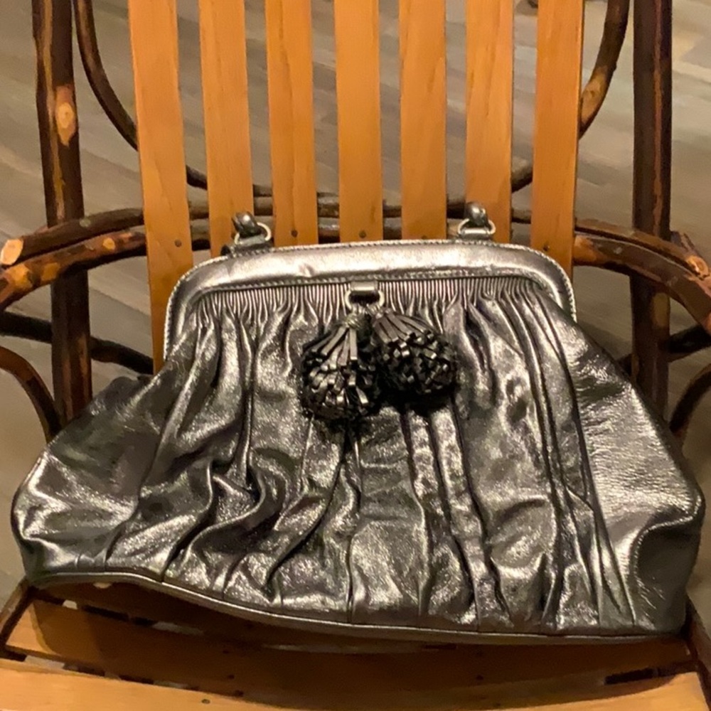 Metallic silver, large handbag, outside, pom-pom detail.